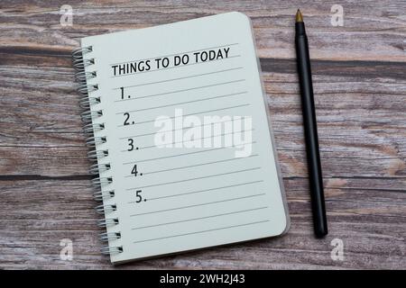 Notebook with things to do today list on wooden desk with pen. Copy space. Stock Photo