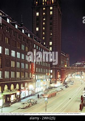 In the 1950s. An evening view of Kungsgatan in Stockholm Sweden. A Volvo 444 and a Volvo Duett is parked in the street. The south of the two towers (Kungstornen) in the middle, once the headquarters of the company LM Ericsson. 1958 Stock Photo