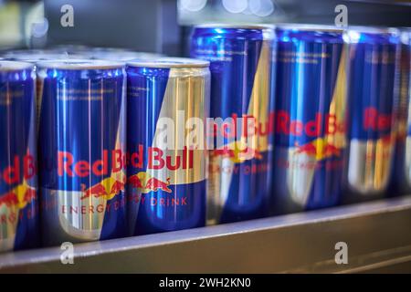 Aluminum cans of Red Bull soda energy drink of different sizes and volumes on a shelf in store. Retail, beverage editorial. Bishkek, Kyrgyzstan - 26 M Stock Photo