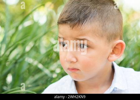 Little boy looking away outdoors Stock Photo
