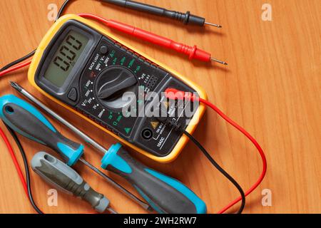 Digital multimeter and screwdrivers on table. Maintenance and repair concept Stock Photo