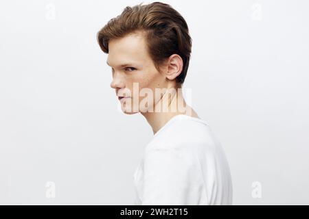 Stylish and Confident: Handsome Young Man with a Trendy Hair Style Posing in a Modern Studio Stock Photo