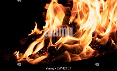 Cooking on a cauldron on a fire. Flames of fire in the dark. Stock Photo