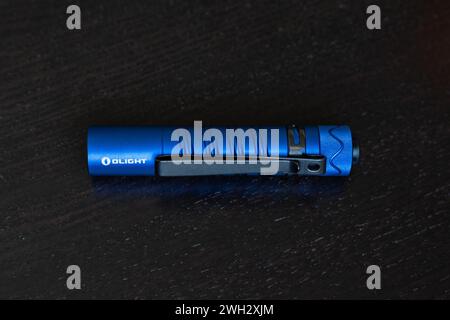 A blue OLIGHT Warrior Mini tactical flashlight Stock Photo