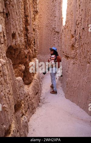 photographer hiking through cathedral gorge slot canyon Stock Photo
