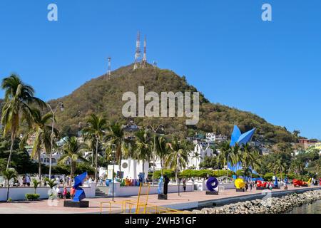 Manzanillo, Mexico  - 16 January 2024: People walking past colourful sculptures on the city's promenade Stock Photo