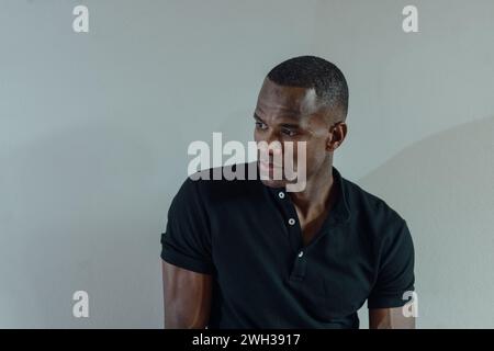 young black african american man wearing a black shirt as he poses for the camera high res image Stock Photo