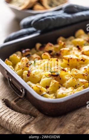 Baked crispy potatoes with rosemary in an old baking dish. Stock Photo