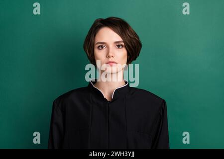 Photo of beautiful lovely serious woman judge attorney wearing black robe coat isolated on green color background Stock Photo