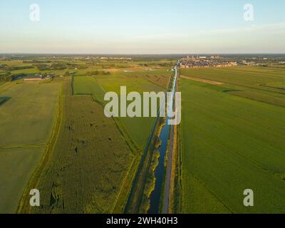High angle view of agricultural fields and town on background against blue sky Stock Photo