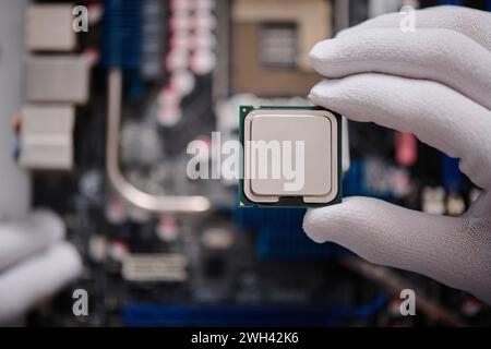 Unrecognizable electronic repairman carefully holding central processing unit with his fingertips Stock Photo