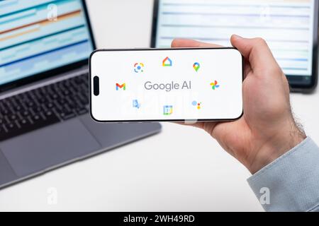 PRAGUE, CZECH REPUBLIC - JANUARY 21 2024: Google AI logo on the screen of a cell phone in business mans hand and laptop on the background.  Stock Photo