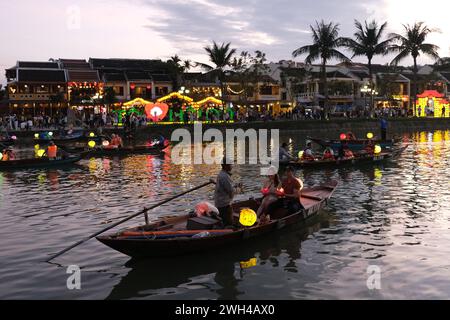 Couple take a romantic boat ride at dusk on a lantern boat in the historic town of Hoi An, Vietnam Stock Photo