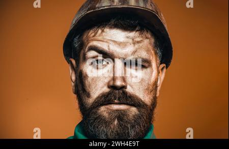 Closeup portrait of serious handsome engineer, architect in hard hat. Mechanical worker, male builder in construction hardhat. Bearded miner Stock Photo