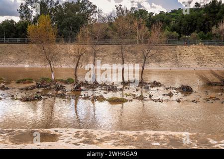 Glendale, CA, USA – February 7, 2024: After days of heavy rain, water flows through the flood control channel in the Glendale Narrows portion of the L Stock Photo