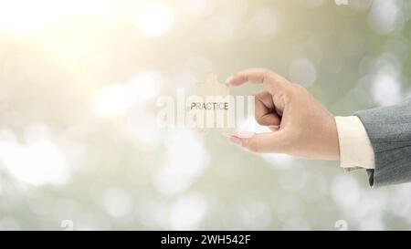 Business hand holding pieces of a jigsaw puzzle with practice text. Theory and practice concept Stock Photo