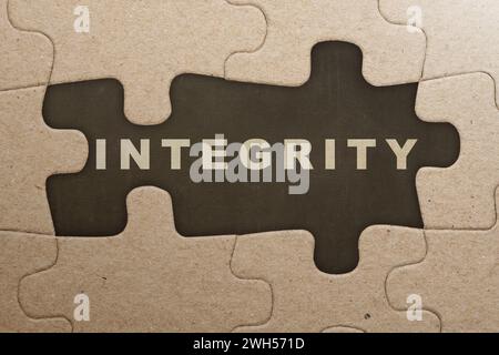 Piece of missing jigsaw puzzle with integrity text on a black background. Reputation integrity concept Stock Photo