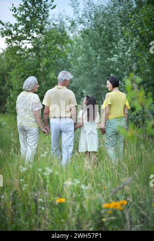 Elderly couple with their daughter and granddaughter walking in a field Stock Photo