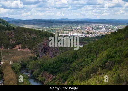 Bad Munster, Germany - May 12, 2021: Nahe River surrounded by cliffs with a town in the background on a spring day in Rhineland Palatinate, Germany. Stock Photo
