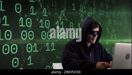 Image of caucasian male hacker over binary code on green background Stock Photo
