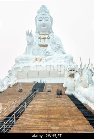 Chiang Rai city,Northern Thailand-April 01 2023:Tourists climb the many steps,to enter the huge,hollow structure,where one can take a lift up to it's Stock Photo
