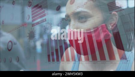 Coronavirus statistical data processing against woman exercising on stationary bike at gym Stock Photo