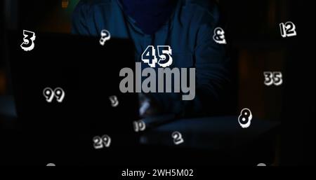 Image of floating numbers over caucasian man using laptop Stock Photo