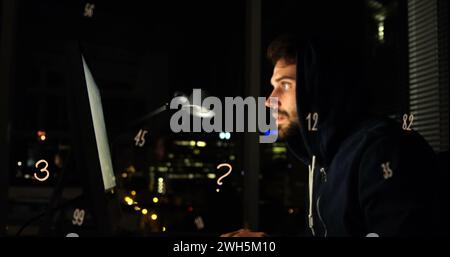 Image of floating numbers over caucasian man using computer Stock Photo