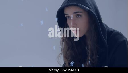 Image of numbers over caucasian hacker using computer Stock Photo