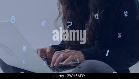 Image of numbers over caucasian hacker using computer Stock Photo