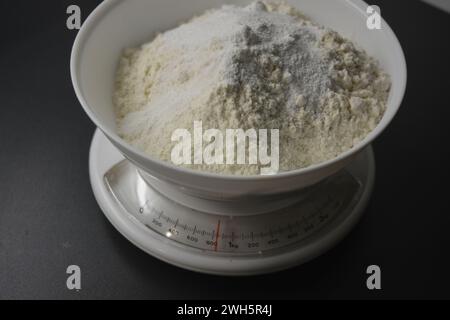 Homemade, tabletop, white weights with wheat flour are located on the gray countertop of the kitchen. Stock Photo