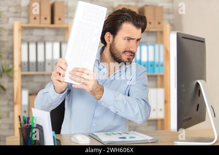 extremely angry businessman smashing his computer Stock Photo