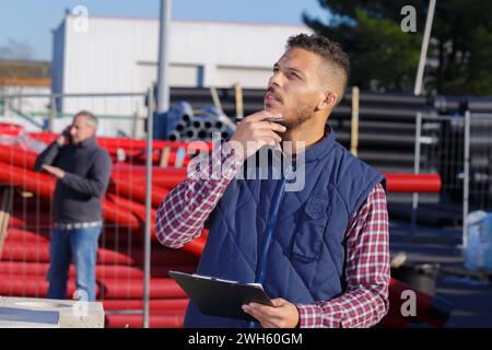thoughtful young male worker in protective wear at construction site Stock Photo
