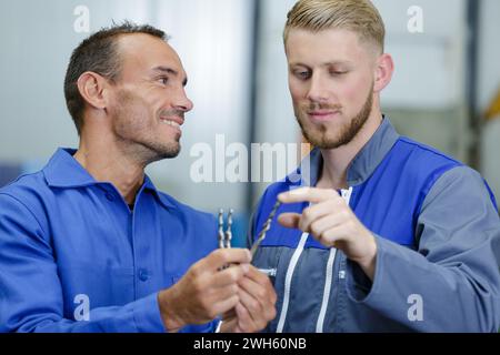 engineer with apprentice discussing tools Stock Photo