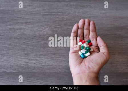 Hand holding pile of colorful pills. Copy space for text. Drug abuse, addiction concept. Stock Photo