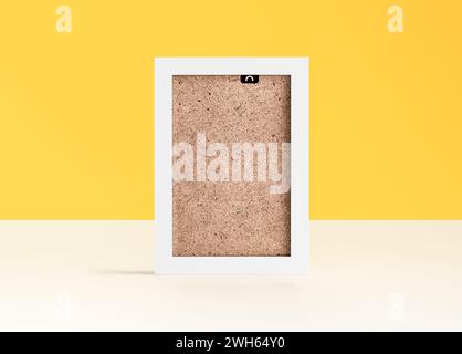 White blank photo frame on white table in front of yellow background with copy space Stock Photo