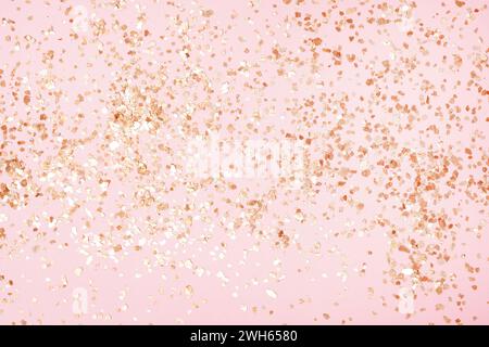 Golden sparkles on pink pastel trendy background. Festive backdrop for your projects. Stock Photo