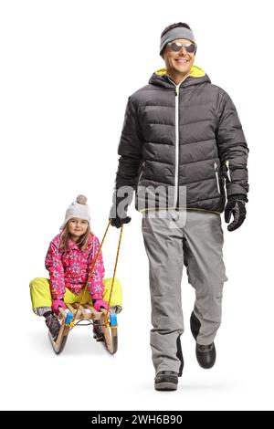 Father pulling daughter on a wooden sled and walking towards camera isolated on white background Stock Photo