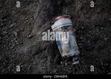 An abandoned beer can on the ground and wrapped in a piece of newspaper clearly depicting Rishi Sunak from the Eat out to Help out campaign Stock Photo