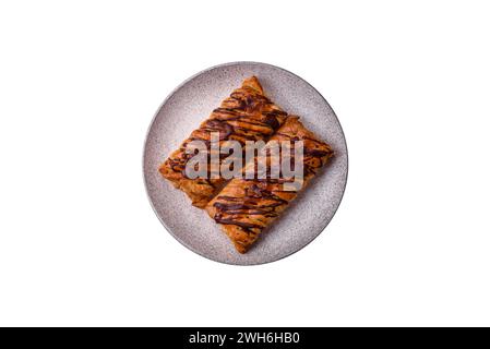 Delicious crispy sweet puff pastry with chocolate and salted caramel on a dark concrete background Stock Photo
