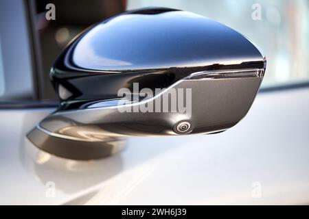 Luxury car detail left back mirror with parking camera and side repeater lamp closeup. 360 terrain surround system option of modern car. Side view Stock Photo