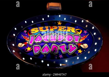 WMS Super Jackpot Party illuminated slots header topper on a gaming machine in an amusement arcade, September 2022. Stock Photo