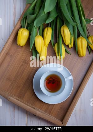 White coffee mug with yellow tulips. Space for text or design. Stock Photo