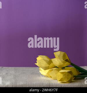 yellow tulips and origami rabbit with violet background Stock Photo