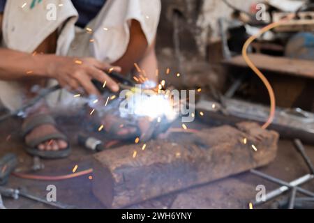 Welders work on welding metal. Men working in welding workshop. blurry photo Stock Photo