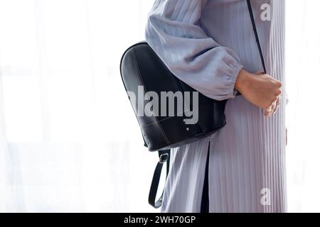 Muslim woman standing with sling bag on white background. Travel concept Stock Photo