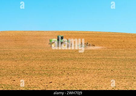 agricultural landscape of a John Deere tractor closeup during spring ploughing in the Overberg, Western Cape, South Africa Stock Photo