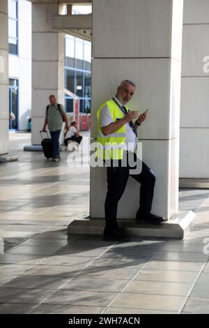 Athens Greece Athens International Airport (AIA) Eleftherios Venizelos Man Wearing High Visibility Vest Using Mobile Phone Stock Photo