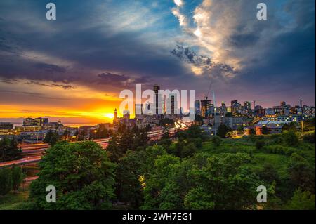 Dramatic sunset over Seattle skyline with highway in foreground Stock Photo