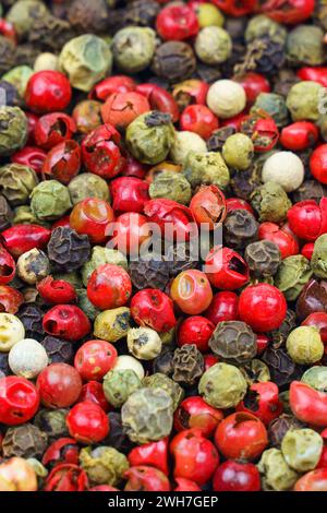 Background image. Top view of a mix of red, green, black, gray and white peppercorns. Vertical frame. Stock Photo